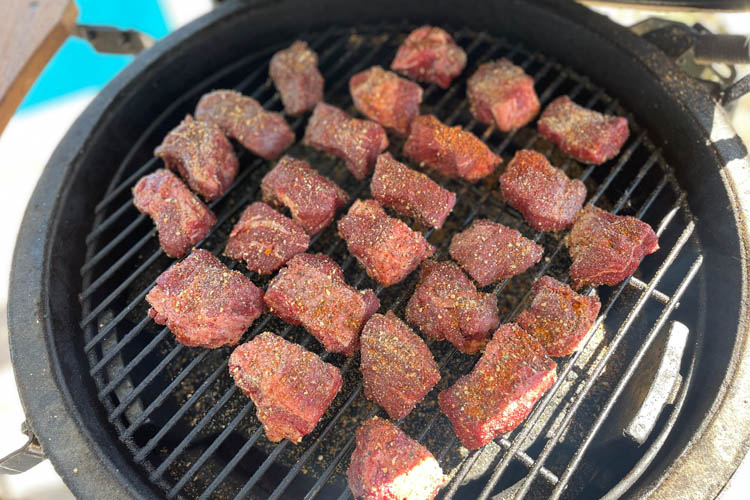 raw seasoned burnt ends on a grill