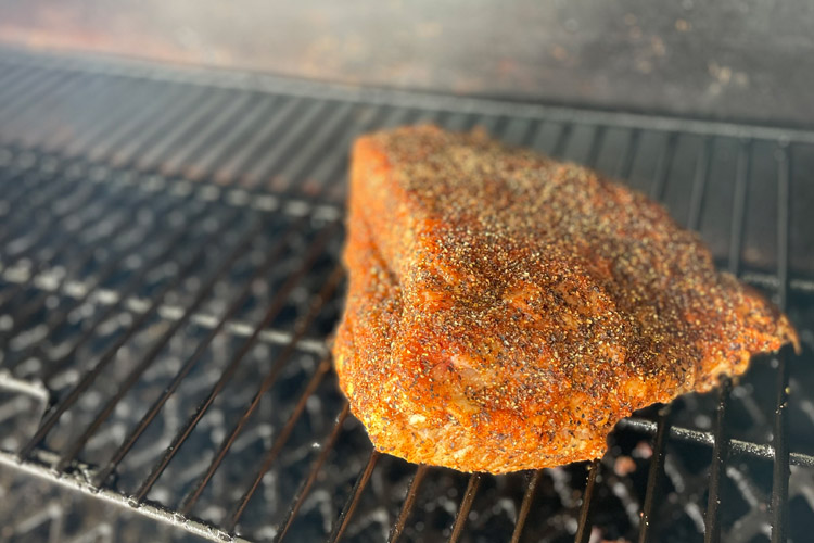seasoned piece of corned beef on the grill