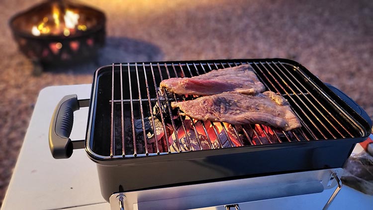 steaks grilling on the weber go-anywhere
