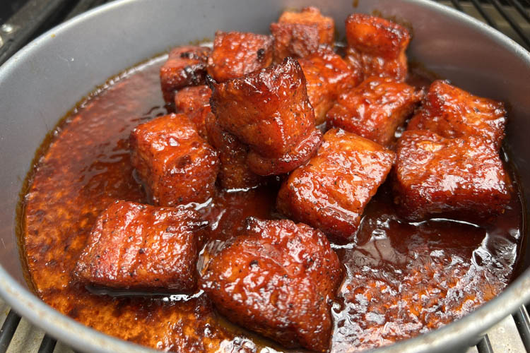 pork cubes in sauce in a metal bowl