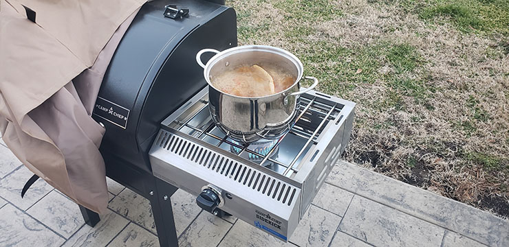 a large pot with boiling crab legs on a camp chef sidekick cooking system