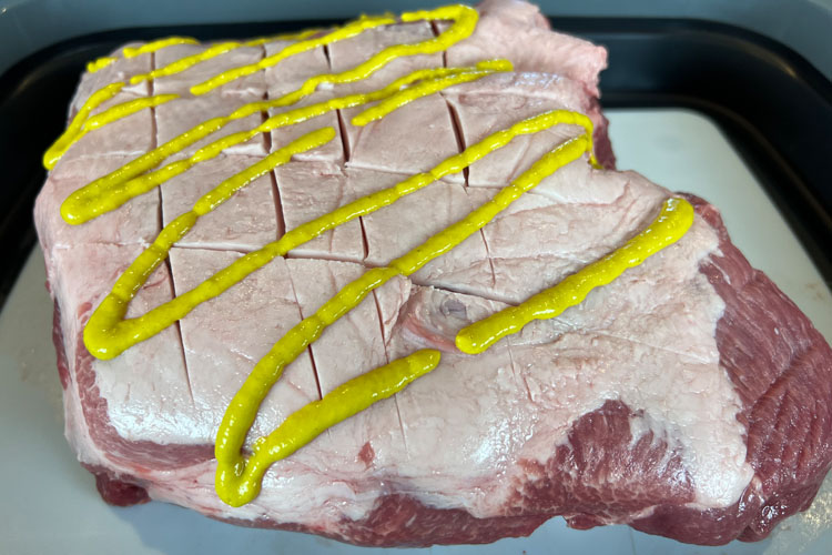 raw pork butt with mustard binder on it