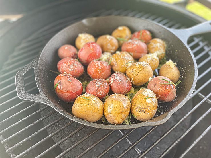 smoked potatoes in a skillet on a smoker