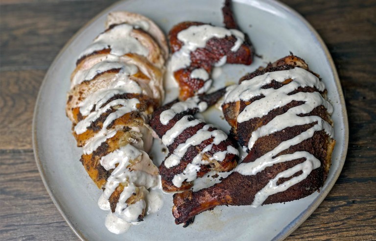 smoked chicken with alabama white sauce on on a plate