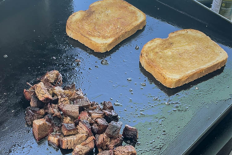 chopped brisket and two slice of bread on a grill