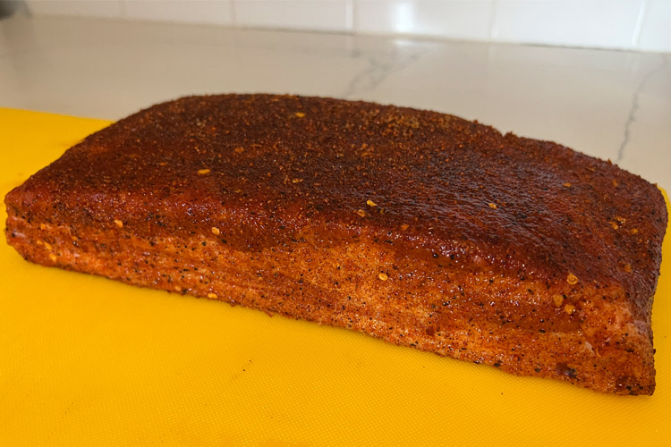 seasoned pork belly on a yellow chopping board