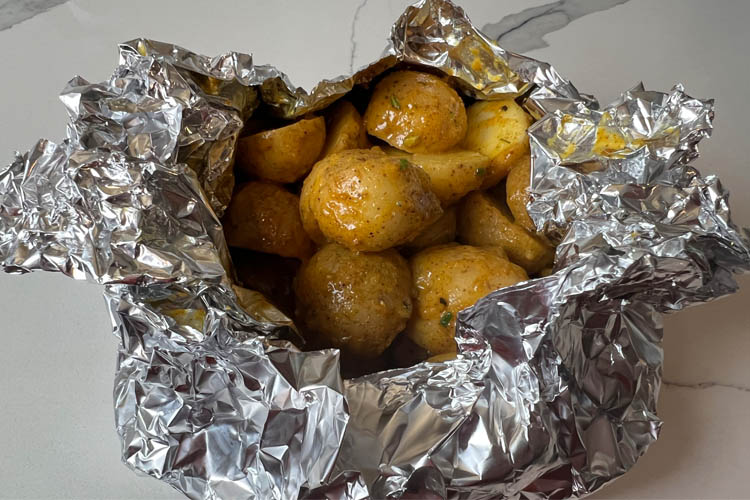 raw potatoes in a foil boat
