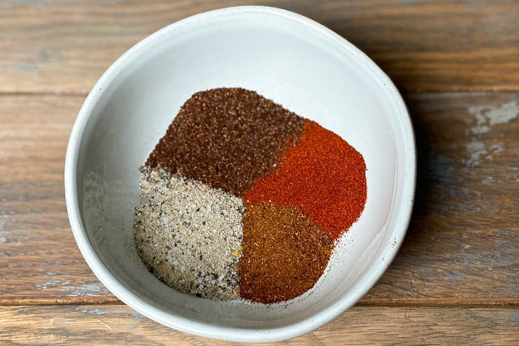 white bowl with salt, pepper, chili and paprika in it