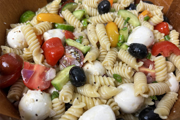 pasta salad ingredients all mixed up with dressing