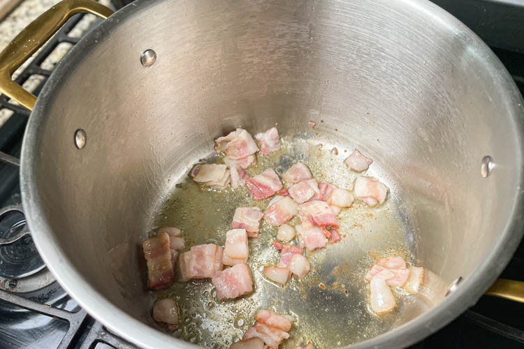 bacon frying in a silver pot