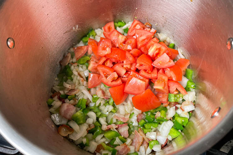 onions, tomatoes, peppers in pot with bacon