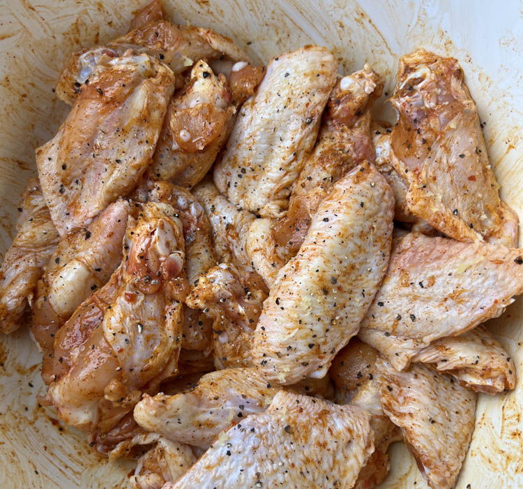 raw wings coated in rub in a bowl