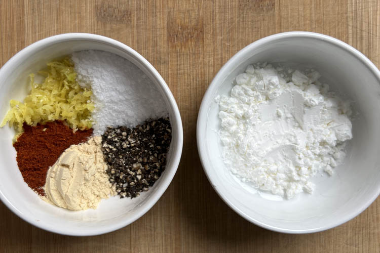 two white bowls with rub ingredients in one and cornflour in the other