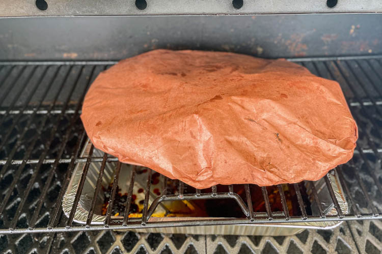 brisket wrapped in butcher paper on the grill