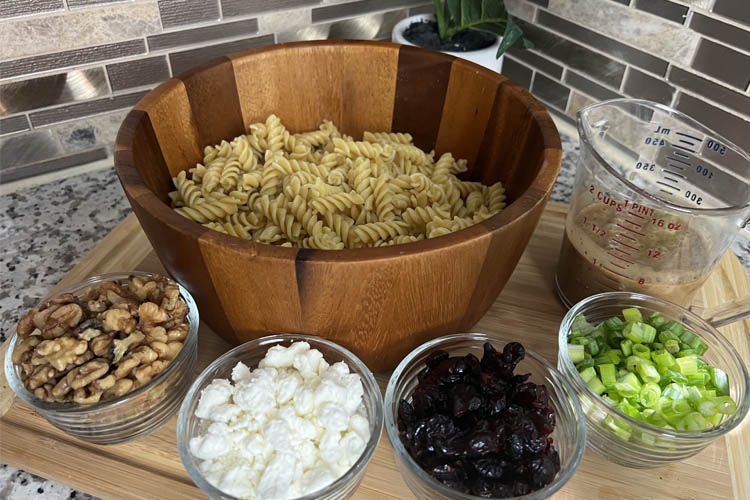 pasta in main bowl, ingredients in small bowls