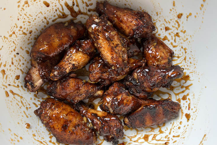 smoked and fried wings in a bowl with sauce