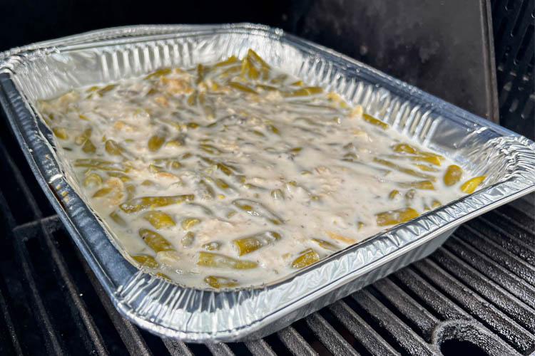 uncooked green bean casserole in aluminum tray on the grill