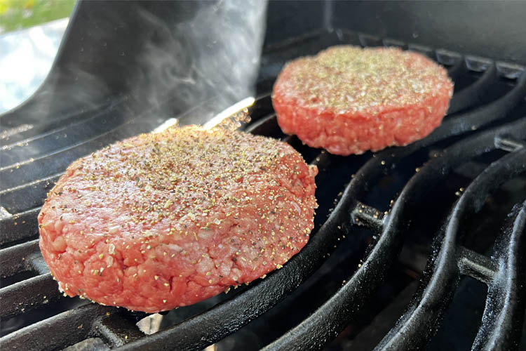raw bison burgers on the grill