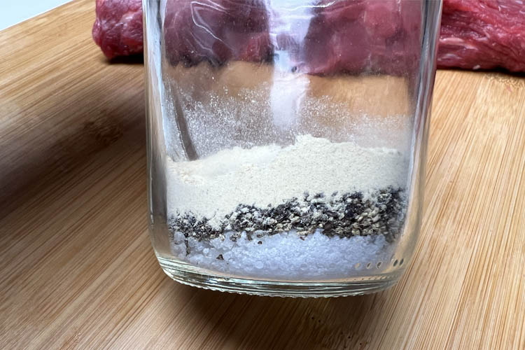 glass jar with salt, pepper and garlic powder in it