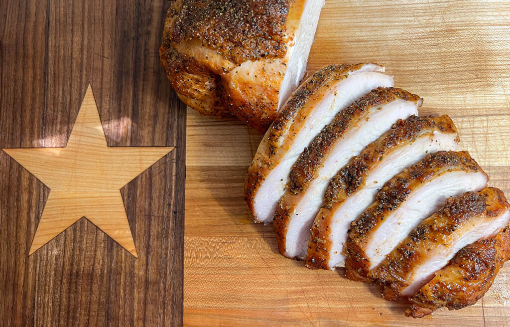 texas smoked turkey breast on wood chopping board