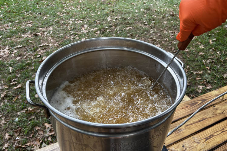 boiling oil in a pot with thermometer testing it