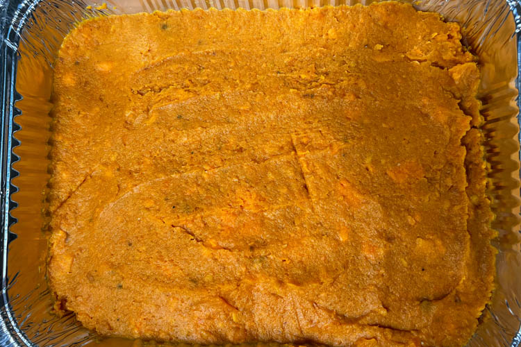 cooked, mashed sweet potato spread in a tin casserole tray