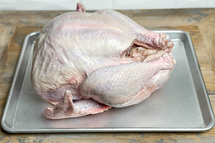 raw whole turkey on a silver tray