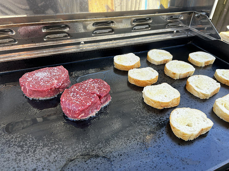 Filet mignon steaks and bread toasts on a Grilla Grills Primate griddle top