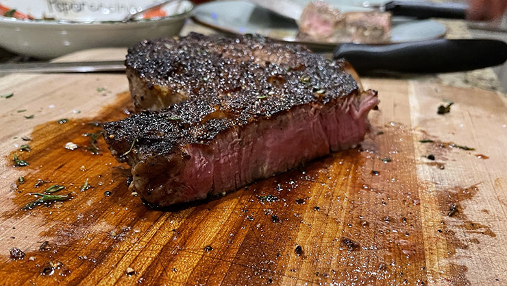 cooked steak on a wooden board