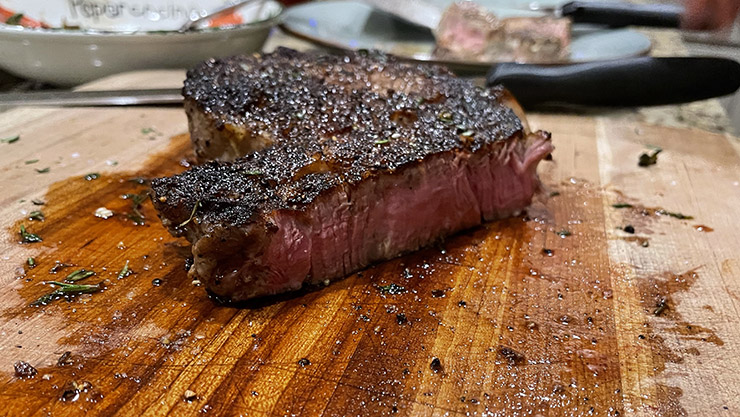 cooked steak on a wooden board