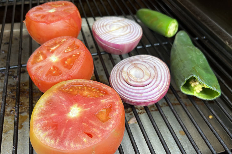 charred tomatoes, onions and peppers on the grill