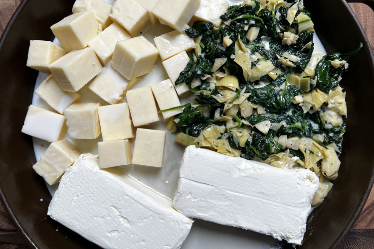 monterray jack, cream cheese, spinich and milk in a cast iron pan