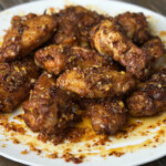 plate full of chicken wings with chili oil suace