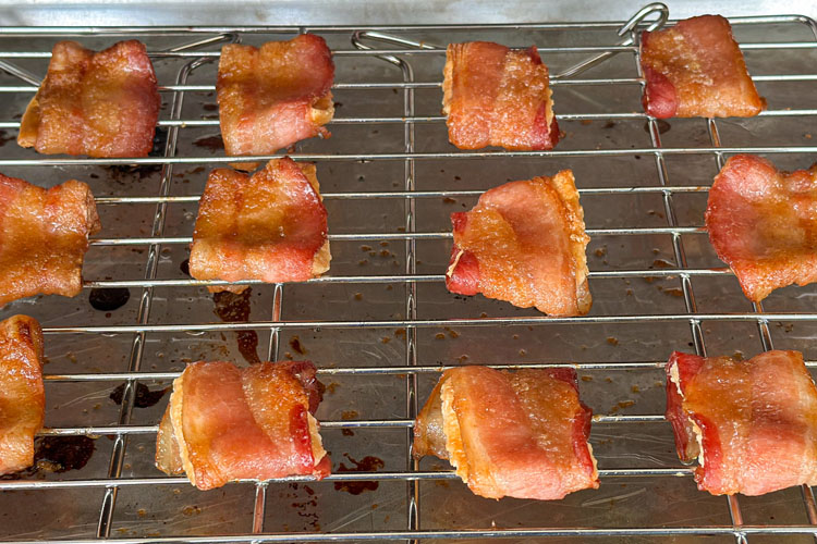 cooked bacon wrapped crackers on a wire rack