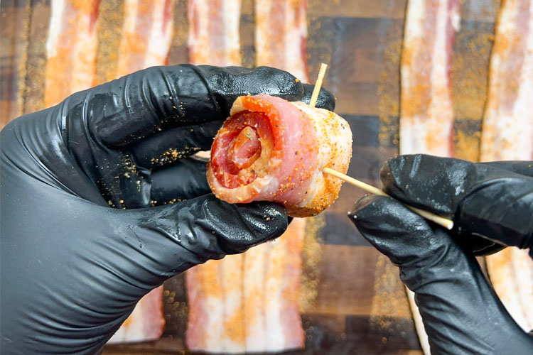 a rolled bacon rasher with toothpicks in it