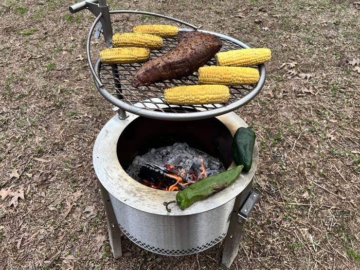 tri tip, corn and peppers cooking on the Breeo Y Series fire pit