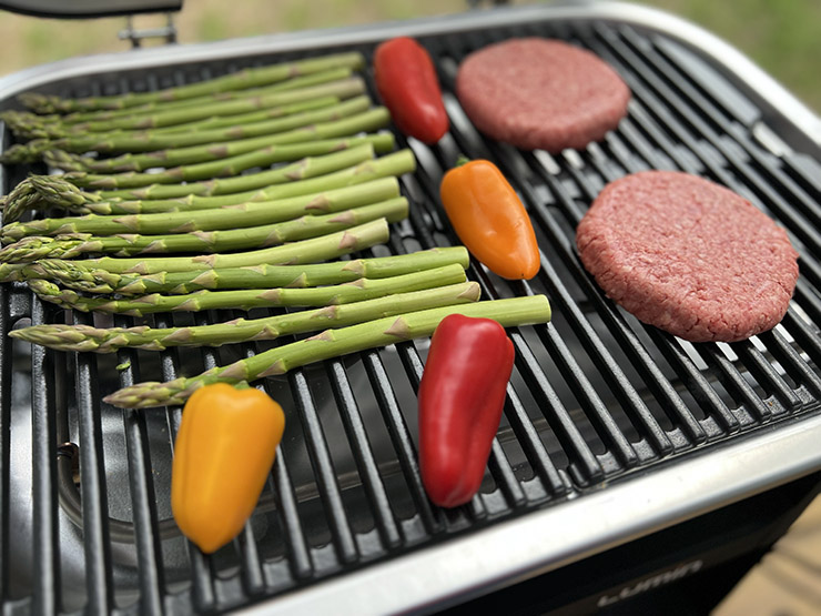 burger patties, asparagus and peppers grilling on Weber Lumin grill