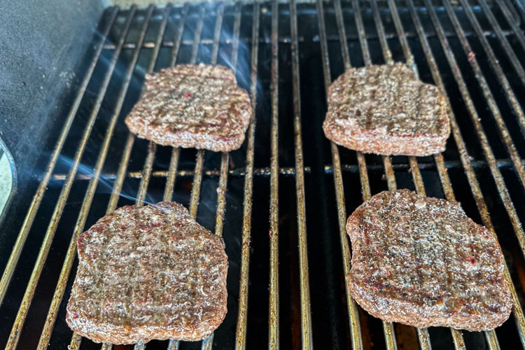 flipped and seasoned burger on the grill