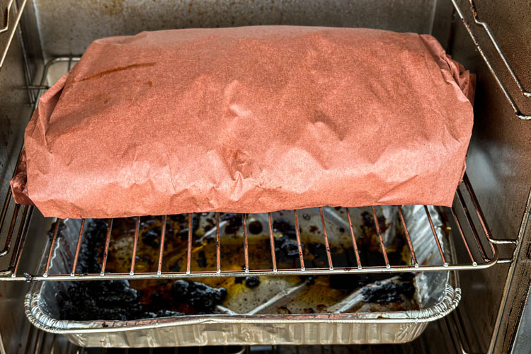 brisket wrapped in butchers paper in the electric smoker