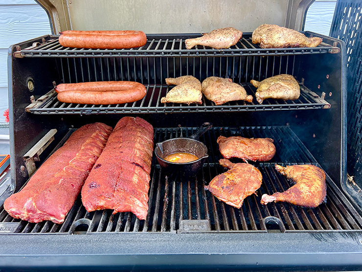 various meats smoking on the Masterbuilt GravityFed™ 1050 grill