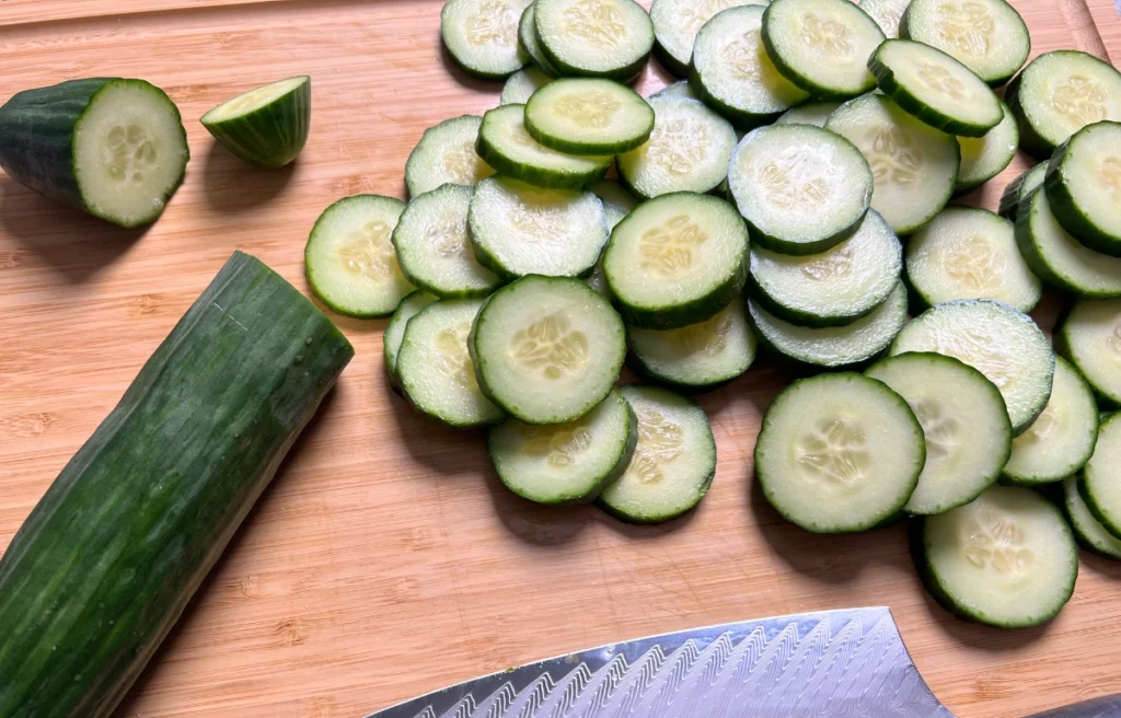 sliced cucumber on a wooden chopping board