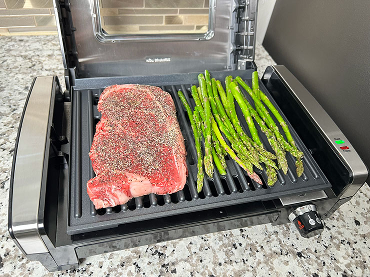 steak and asparagus grilling on the Hamilton Beach electric grill