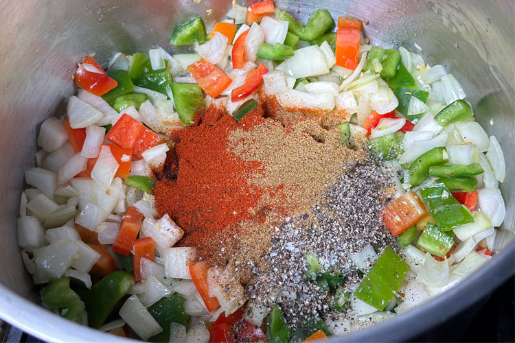 onions, carrots, peppers and spices in a pot