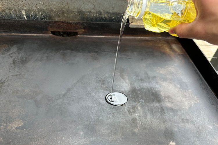 oil being poured on the griddle