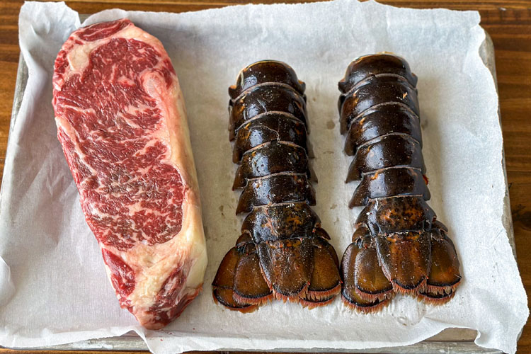 steak and lobster tails on paper