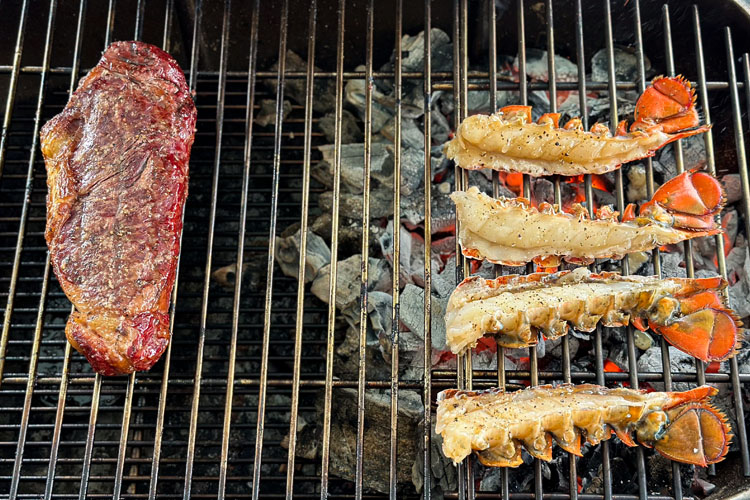 steak and lobster tails on the grill