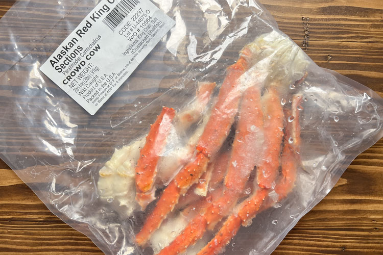 a bag of crab legs on wooden board