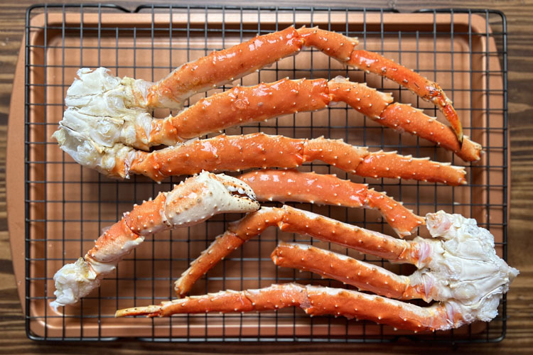 crab legs on a wooden chopping board