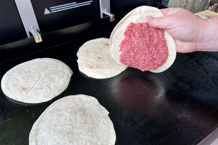 tortillas being placed on a griddle
