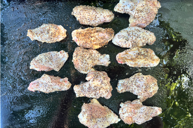 uncooked wings on the griddle